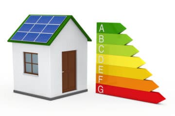 Hus med solpaneler på taket och energimärkningsskala från A till G som representerar byggnadens energiprestanda.